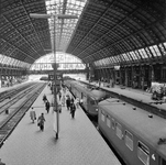 854283 Gezicht op de perrons onder de eerste overkapping van het N.S.-station Amsterdam C.S. te Amsterdam.